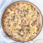 square image of beef stroganoff in a skillet with egg noodles