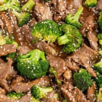 image of beef and broccoli served over cooked white rice with chopsticks with the title of the post on top of th eimag ein pink and black lettering