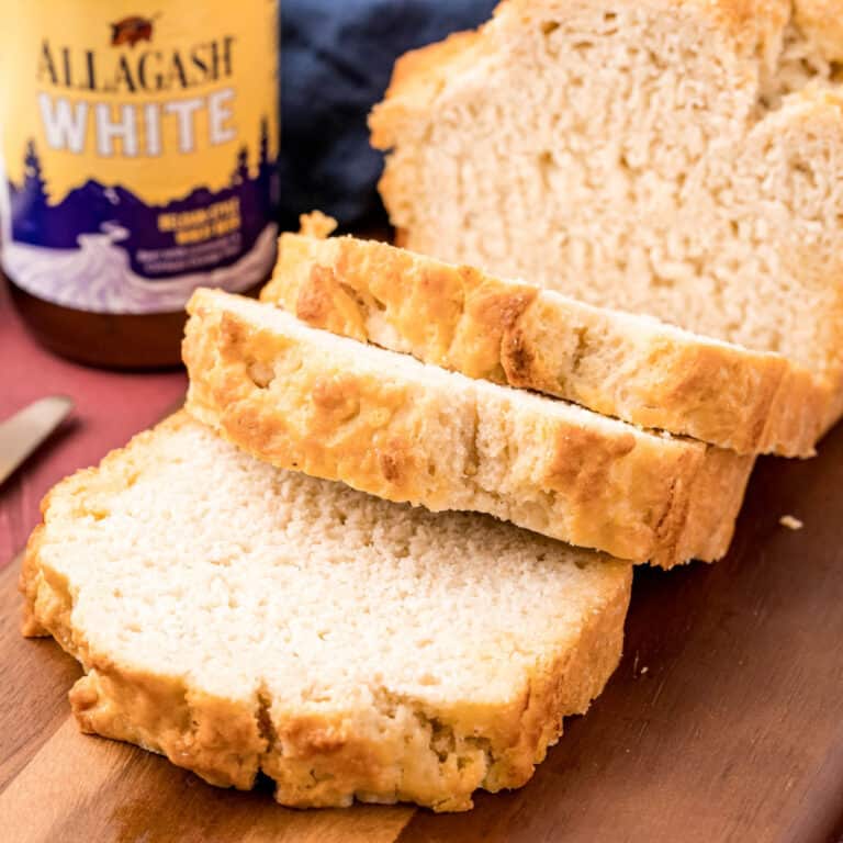 square image of a loaf of beer bread with slices cut from it