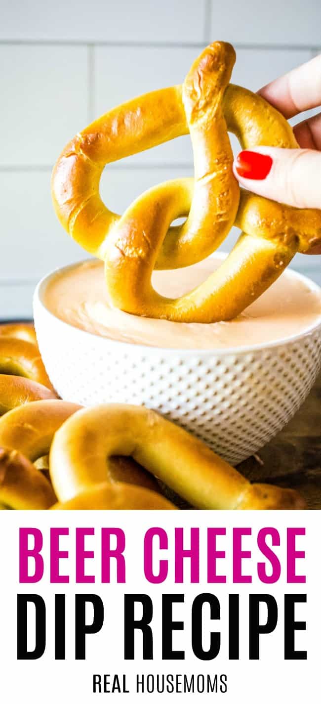 pretzel being dipped into a bowl of beer cheese dip
