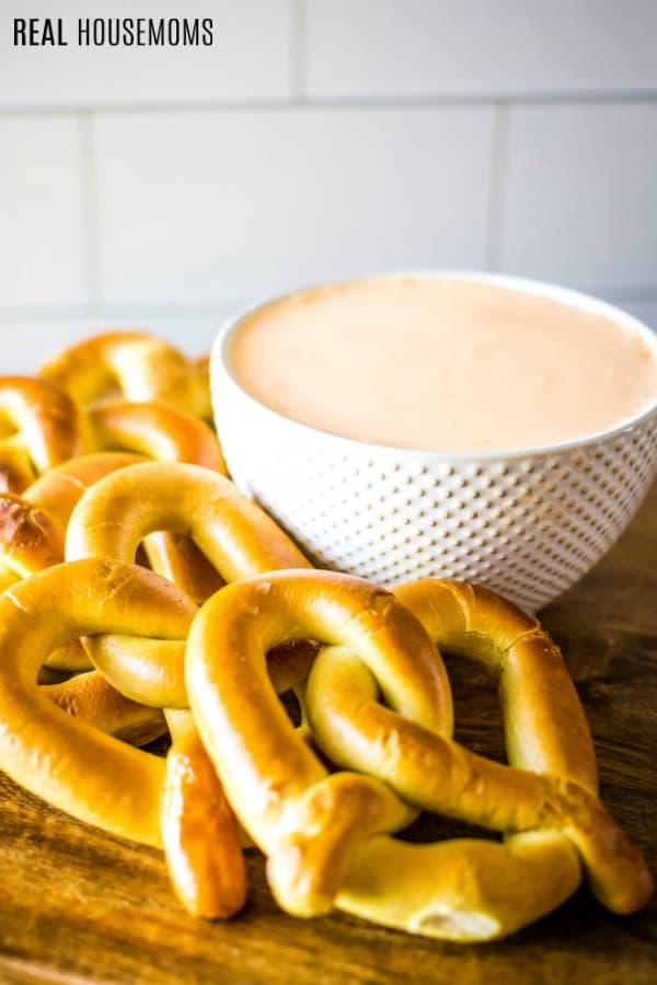 beer cheese dip in a bowl surrounded by pretzels