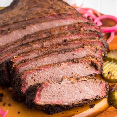square image of beer smoked brisket sliced on a cutting board
