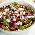 square image of beet salad topped with crumbled feta in a serving bowl