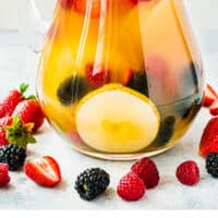 pitcher of berries and pear sangria with recipe name at the bottom