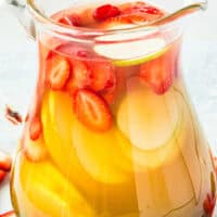 image of a pitcher of berries and pear sangria next to fresh berries. On top of the image is the title of the post in blue and black lettering