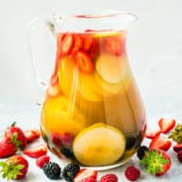 square image of a pitcher of berries and pear sangria next to fresh berries