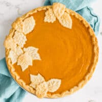 square imgae of a whole pumpkin pie with pie crust leaves