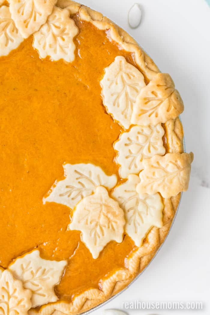 close up of pie crust leaves decorating the top of a pumpkin pie
