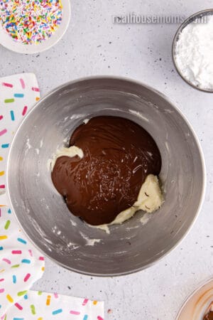 butter and melted chocolate in a stand mixer bowl