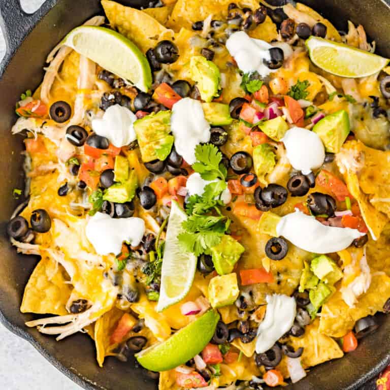 square image looking down at a skillet of black bean and chicken nachos