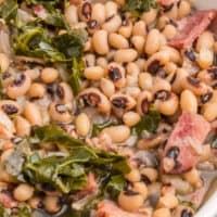 square close up image of black eyed peas & collard greens in a bowl