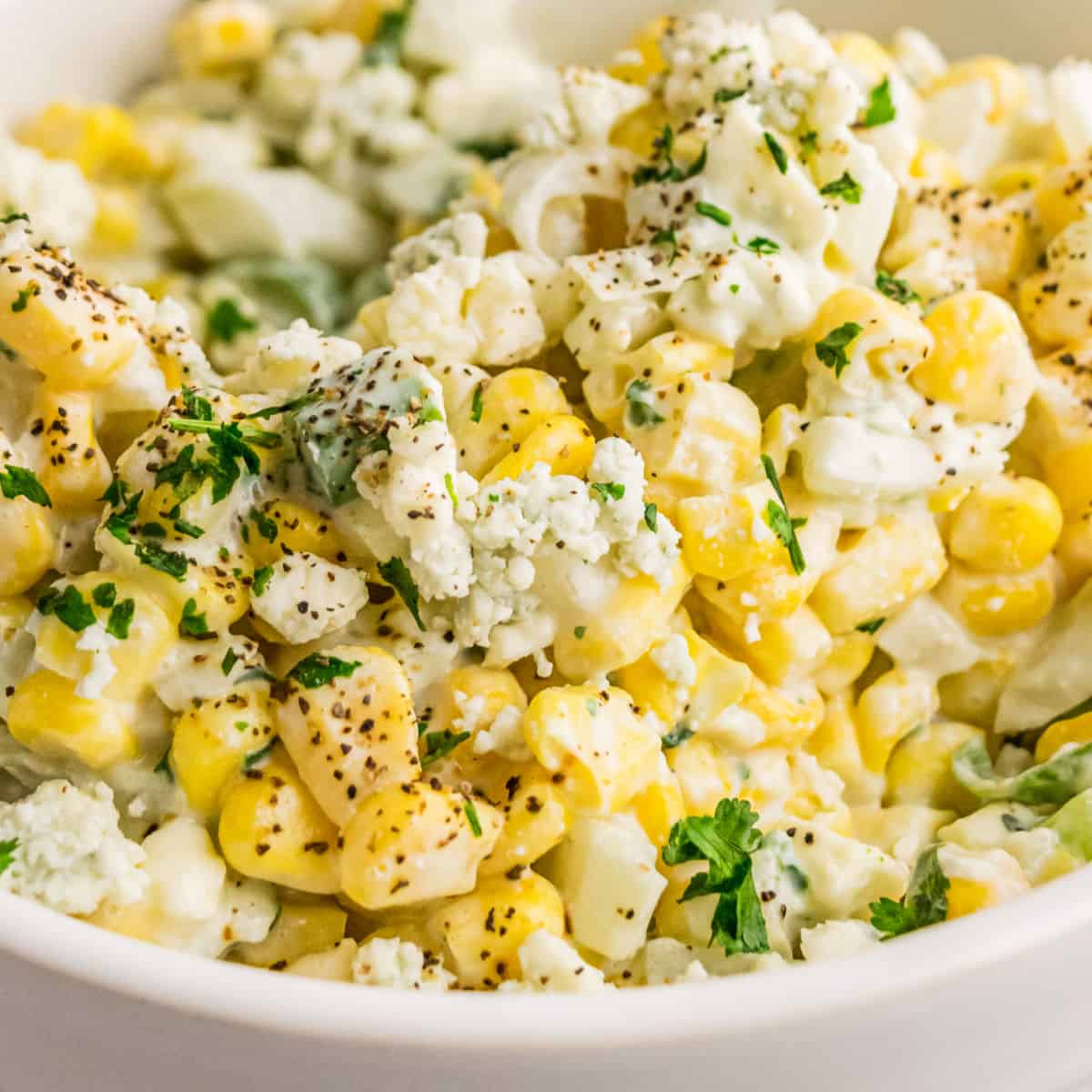 square close up image of blue cheese corn salad in a bowl