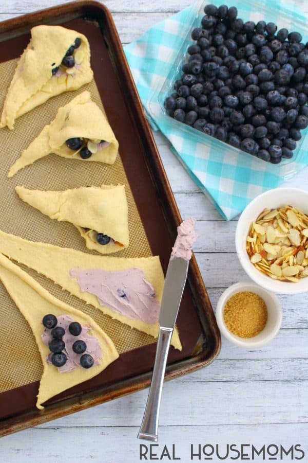 Prepping Blueberry Almond Turnovers with refrigerated crescent roll dough with blueberry cream cheese and blueberries