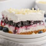 square image of a slice of blueberry lasagna dessert on a plate