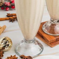 boozy eggnog milkshake garnished with a pirouette cookie with recipe name at the bottom