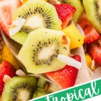 image looking down at a bowl of boozy tropical fruit salad with the title of the post on the bottom of the image