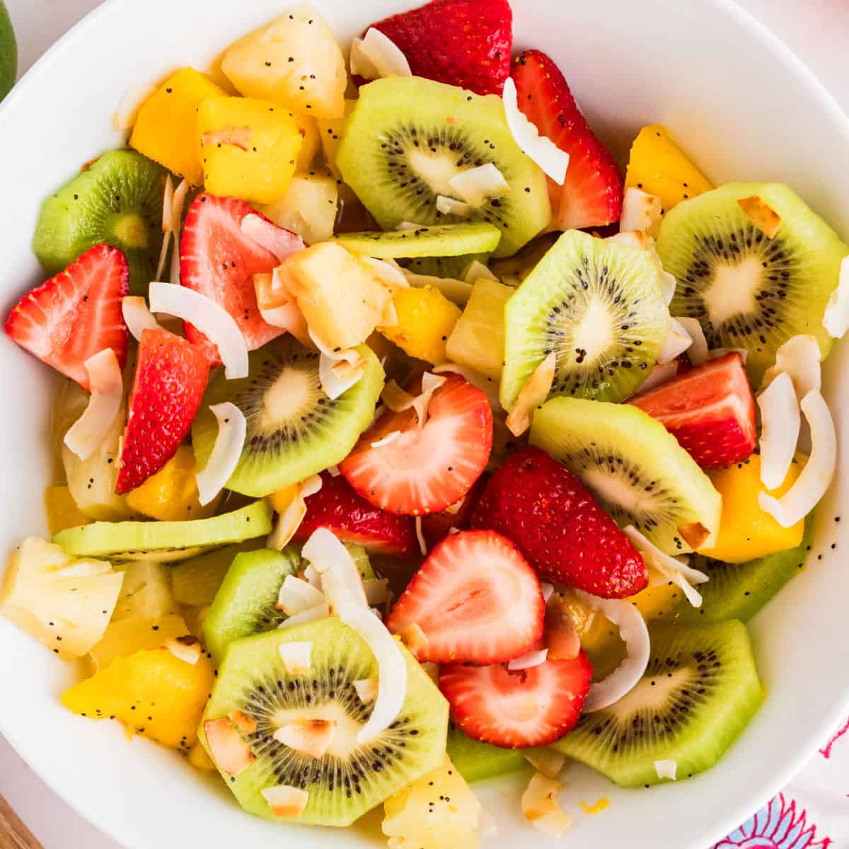 square image looking down at a bowl of boozy tropical fruit salad