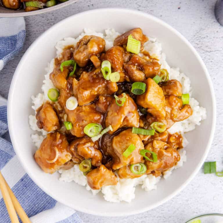square image of bourbon chicken served over rice in a bowl