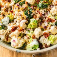 broccoli cauliflower salad in a serving bowl with recipe name at the bottom