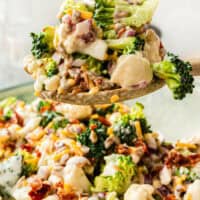 image of serving spoonful of broccoli cauliflower salad over the serving bowl