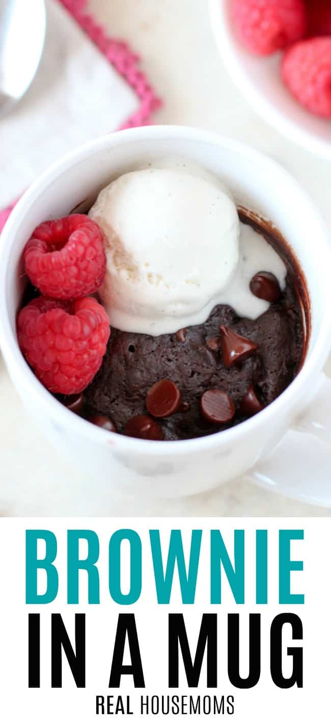 brownie in a mug topped with ice cream and raspberries