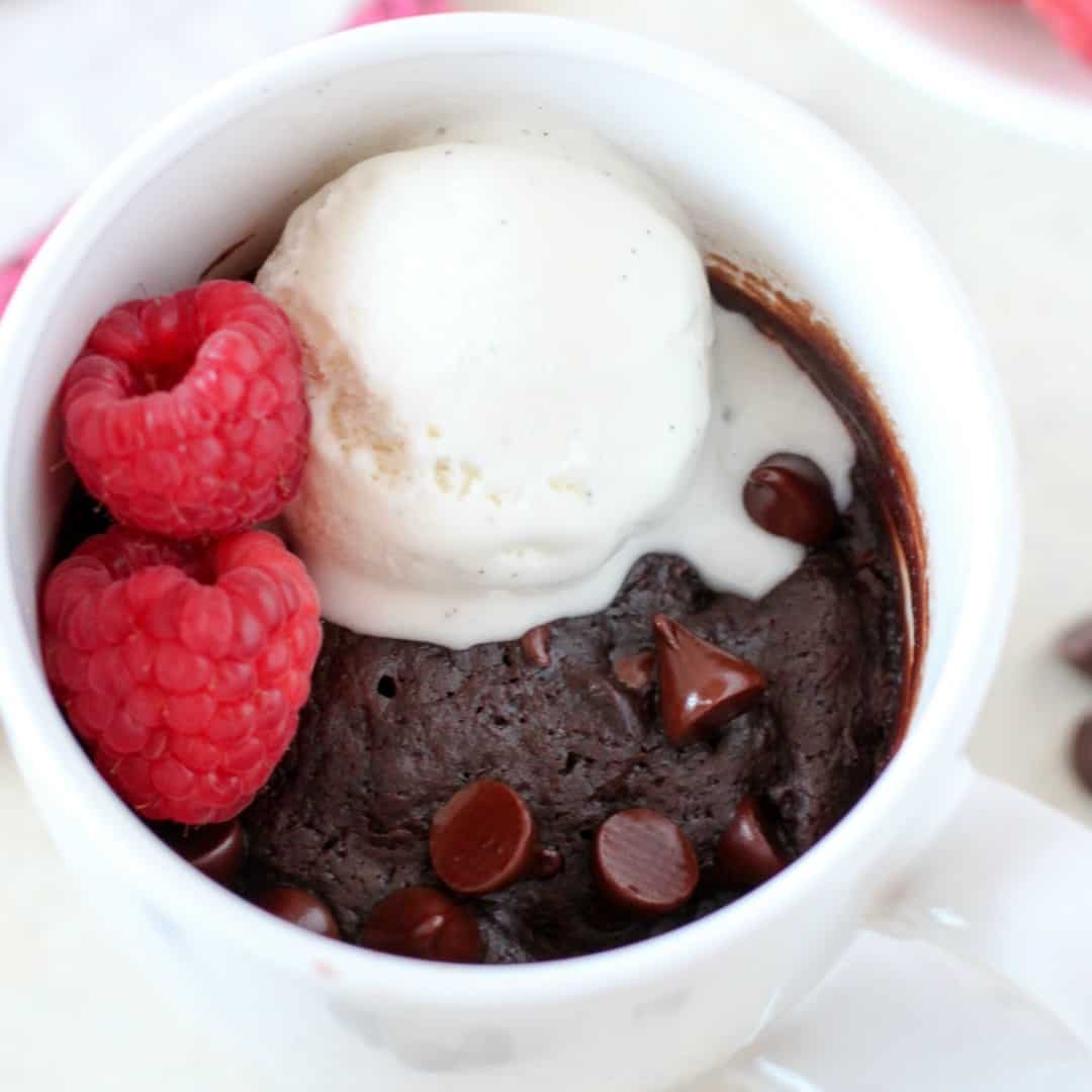 Satisfy your brownie craving in minutes with this fudgy and delicious single-serving Brownie in a Mug! So chocolatey and even better topped with ice cream and raspberries!