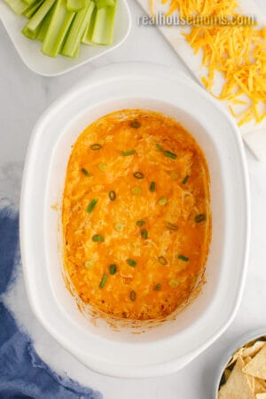 looking down at buffalo chicken dip in the crock pot topped with sliced green onions
