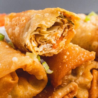 square image of a buffalo chicken egg roll cut open to show the filling
