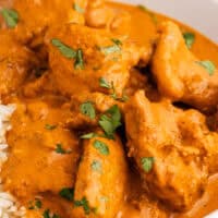 image of butter chicken with cooked rice and naan bread in a bowl on top of the image is the title of the postin blue and black lettering