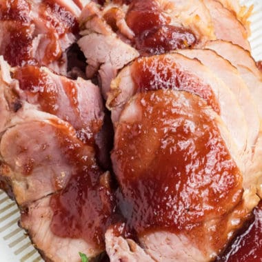 Cranberry Glazed Ham is a little sweet, a little tart, and a whole lot of yummy! A spiced cranberry and orange sauce gives this spiral ham recipe a tangy, caramelized taste that is perfect for your next holiday feast!