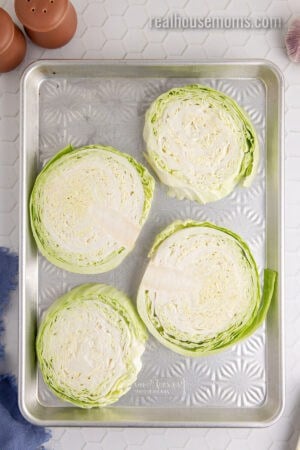 thick slices of green cabbage of a greased baking sheet