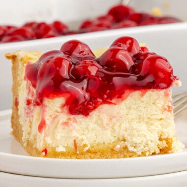 square image of a slice of cake mix cherry cheesecake on a plate in front of the baking dish