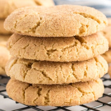 square image of cake mix snickerdoodle cookies stacked up on a cooling rack