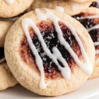 cake mix thumbprint cookies piled up on a plate with recipe name at the bottom
