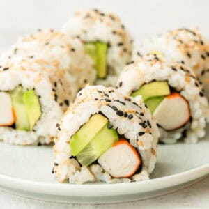 square image of california roll slices standing up on a plate
