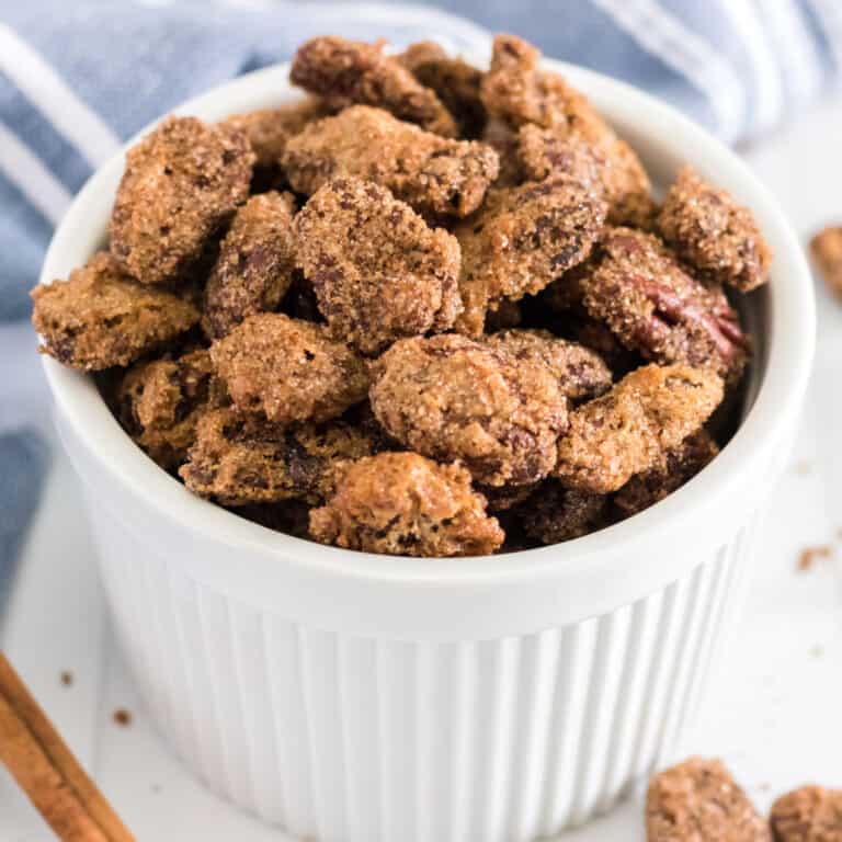 square image of candied pecans in a white bowl