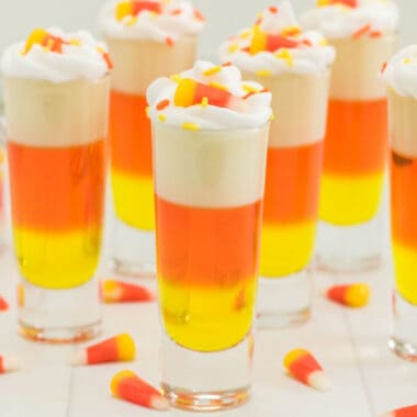 square image of candy corn jello shots with whipped cream, sprinkles, and candy corn