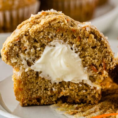 square image of a carrot cake muffin cut in half to show cream cheese filling inside