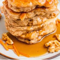 stack of carrot cake pancakes on a plate with recipe name at the bottom