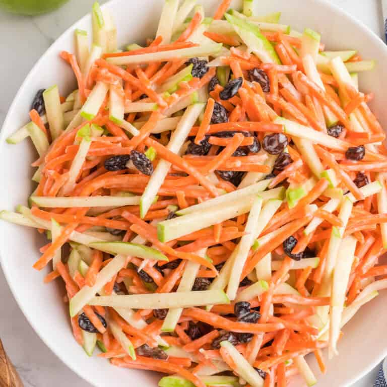 square image of carrot and apple slaw in a serving bowl