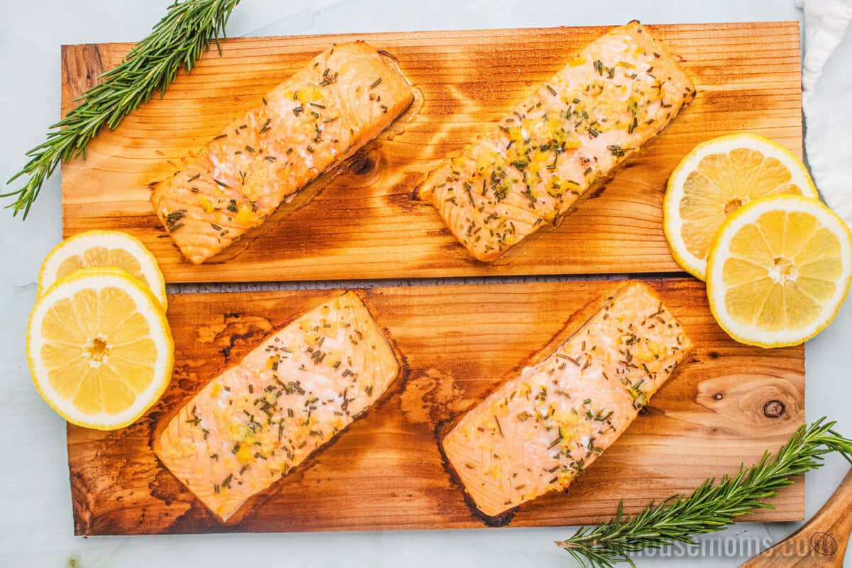 looking down at four salmon fillets on cedar planks after grilling
