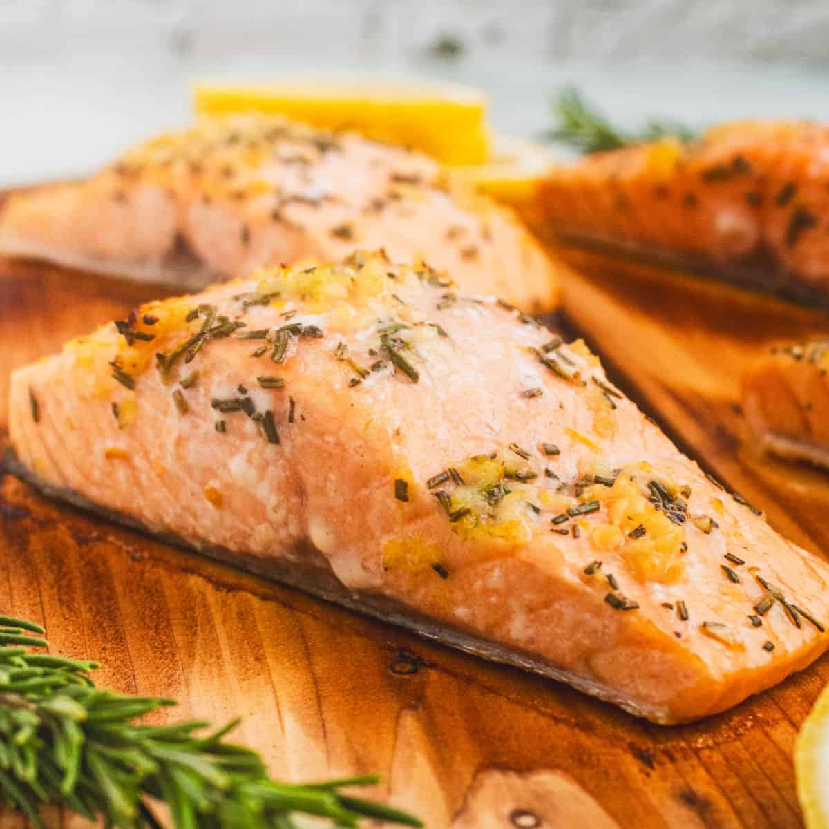 square image of cedar plank salmon fillets on the plank after cooking