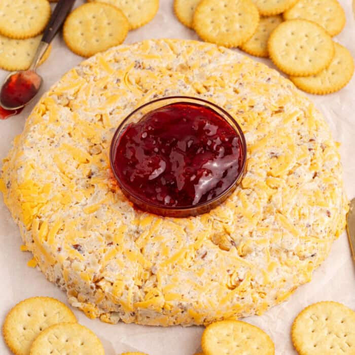 square image of a cheese ring with a bowl of strawberry jam in the center