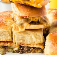 three cheeseburger sliders stacked up on a plate with recipe name at the bottom