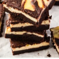 four cheesecake brownies stacked up with recipe name at the bottom