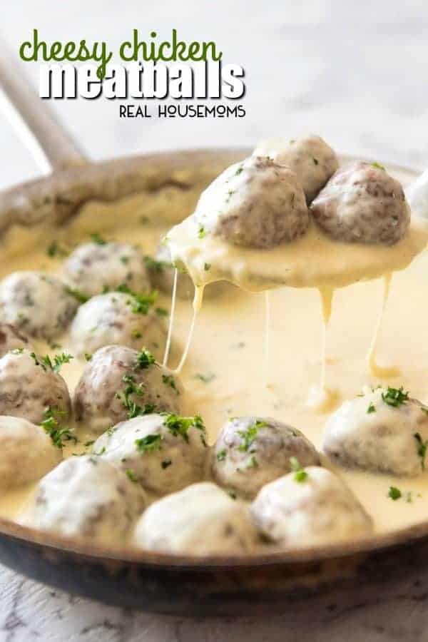 Cheese Chicken Meatballs being lifted out of the skillet by a spoon while cheese sauce drops back into the pan
