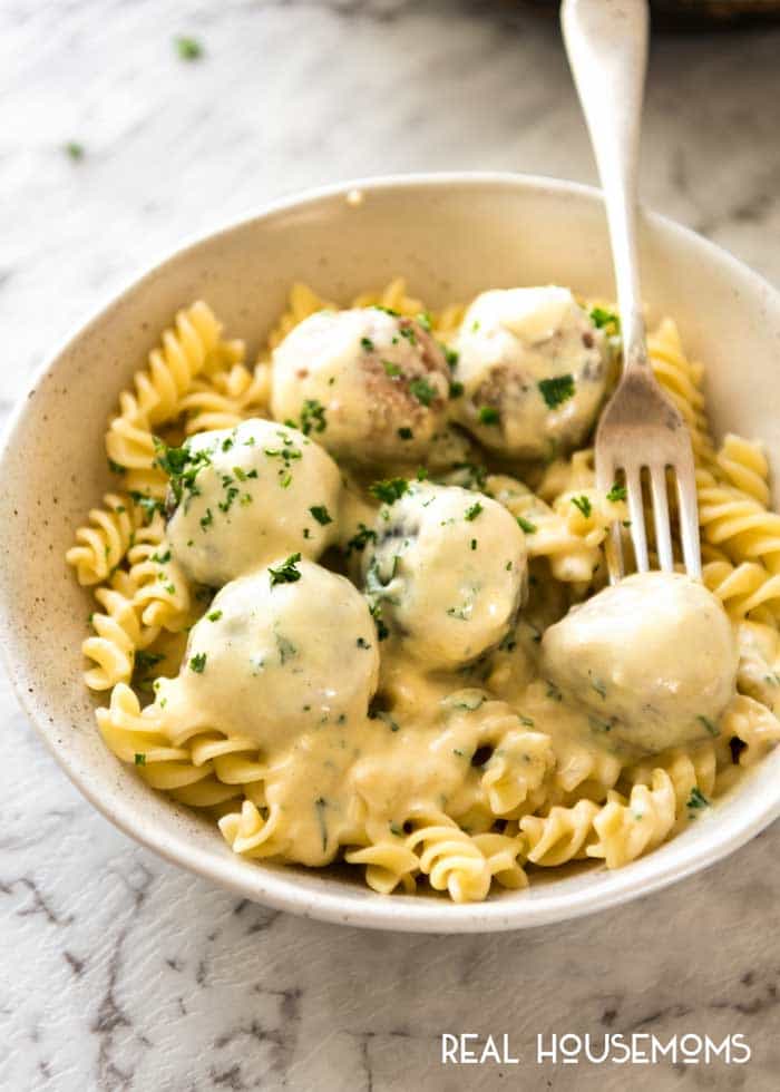 Cheesy Chicken Meatballs served over rotini pasta with extra cheese sauce