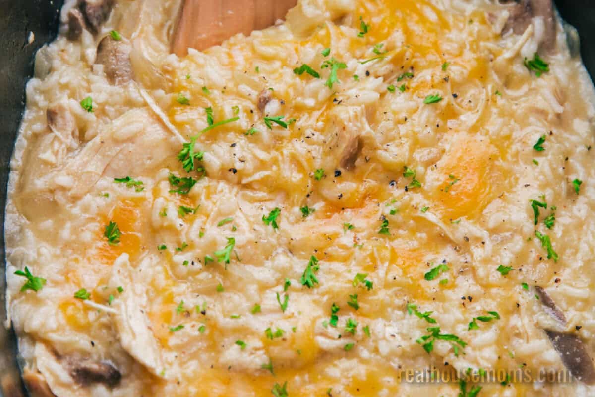 Cheesy Crock Pot Chicken and Rice topped with chopped parsley in a slow cooker