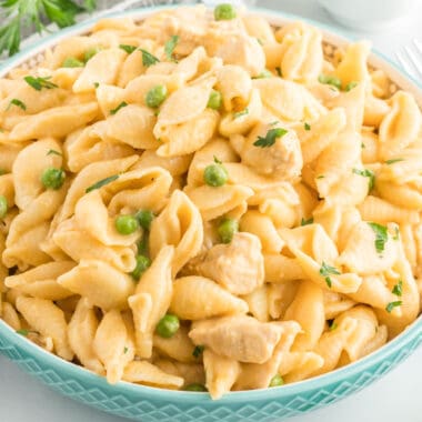 square image of blue serving bowl with cheesy instant pot chicken pasta