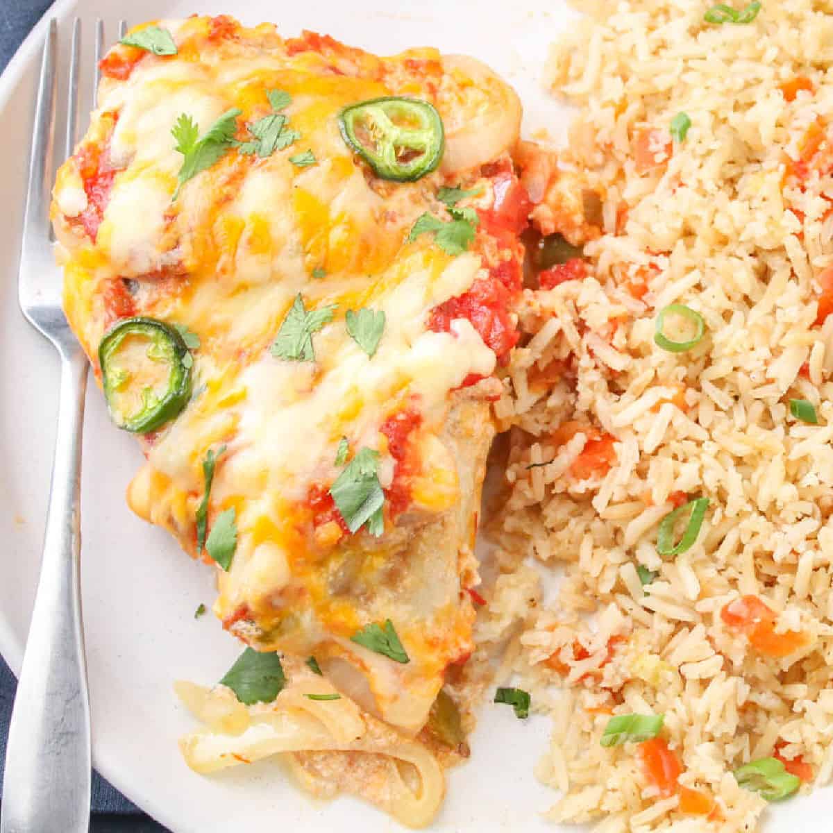 square image of cheesy salsa chicken on a plate with Mexican rice